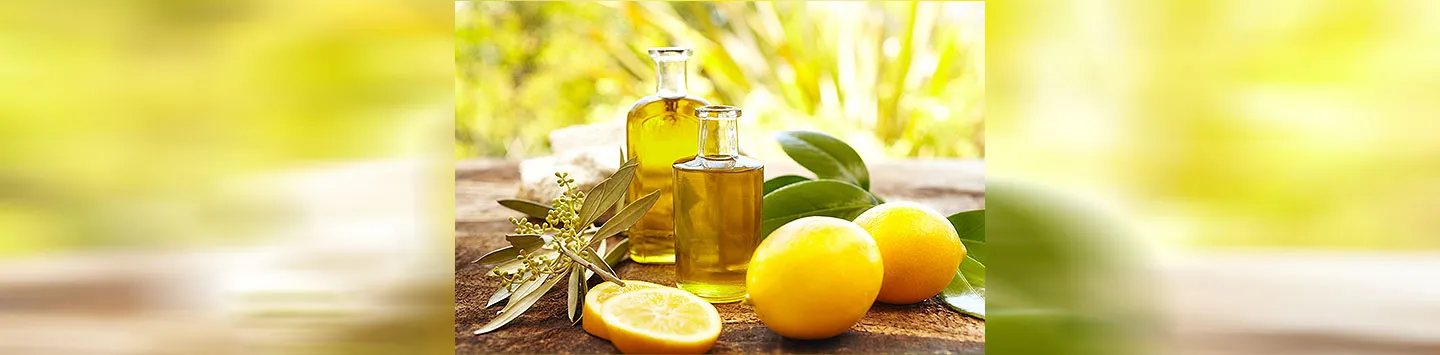 Massage oil bottles at spa outdoors with lemons and green leaves