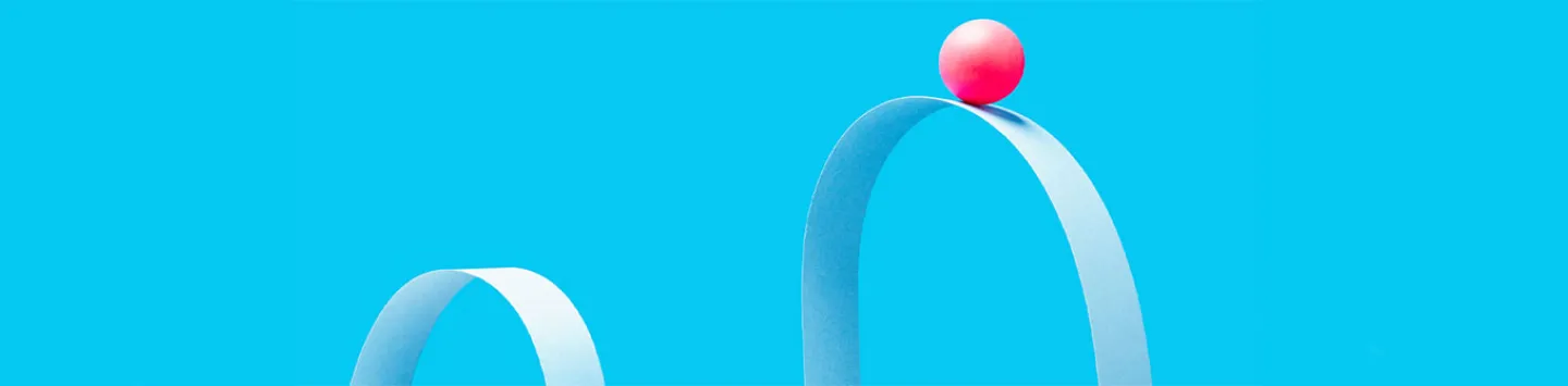 a little red ball on the crest of a wave formed from blue paper, blue background