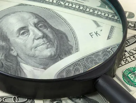 Magnifying glass on 100 dollar bill