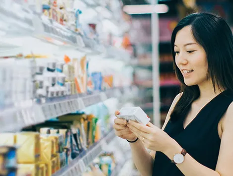 Woman reading nutrition label in supermarket