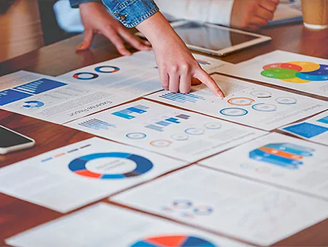 Papers on a table in a boardroom being analyzed by staff