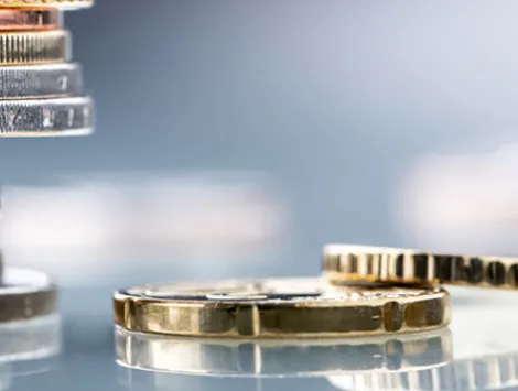 Euro coins built in the shape of a tower that balances before falling, a symbol of financial growth and fall 