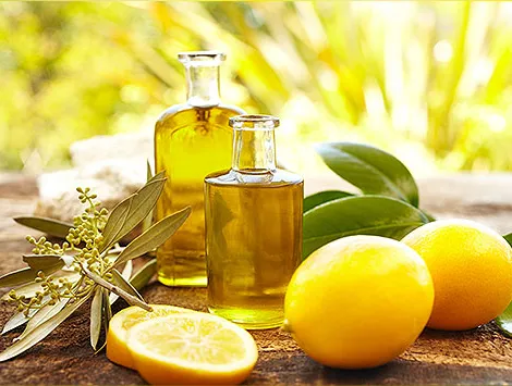 Massage oil bottles at spa outdoors with lemons and green leaves