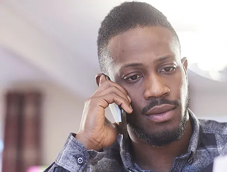 A man talks on his phone while overlooking documents