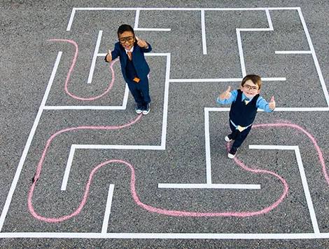 Children playing in a chalk maze