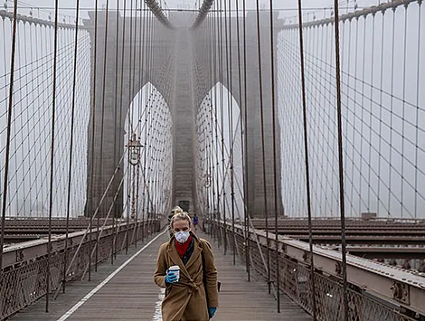 A sole woman on the Brooklyn Bridge wearing a mask during the coronavirus pandemic.