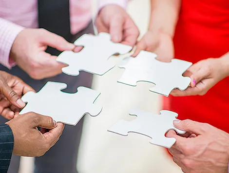 Four people try to put together large puzzle pieces