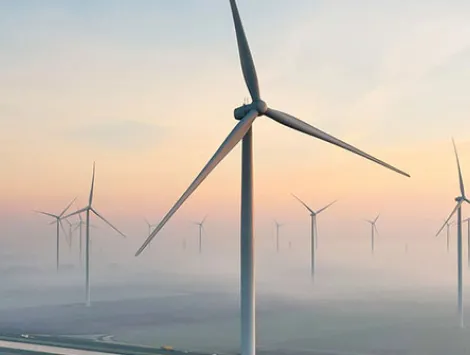 Solar energy field and wind turbines seen from the air during sunrise